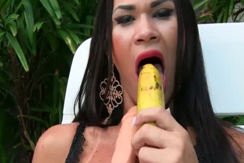 Ladyboy masturbiert mit einer Banane und einem riesigen falschen Penis