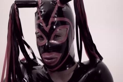 Fetisch-Transe in Latzanzug und Maske stupst